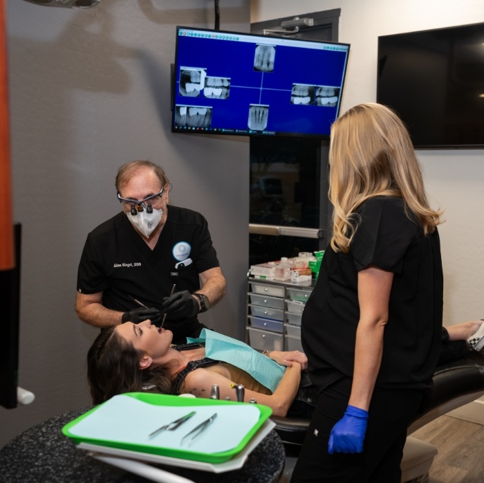 Doctor Siegel and dental assistant treating a dental patient