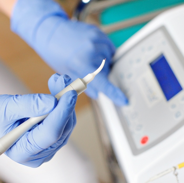 Dentist holding a soft tissue laser device