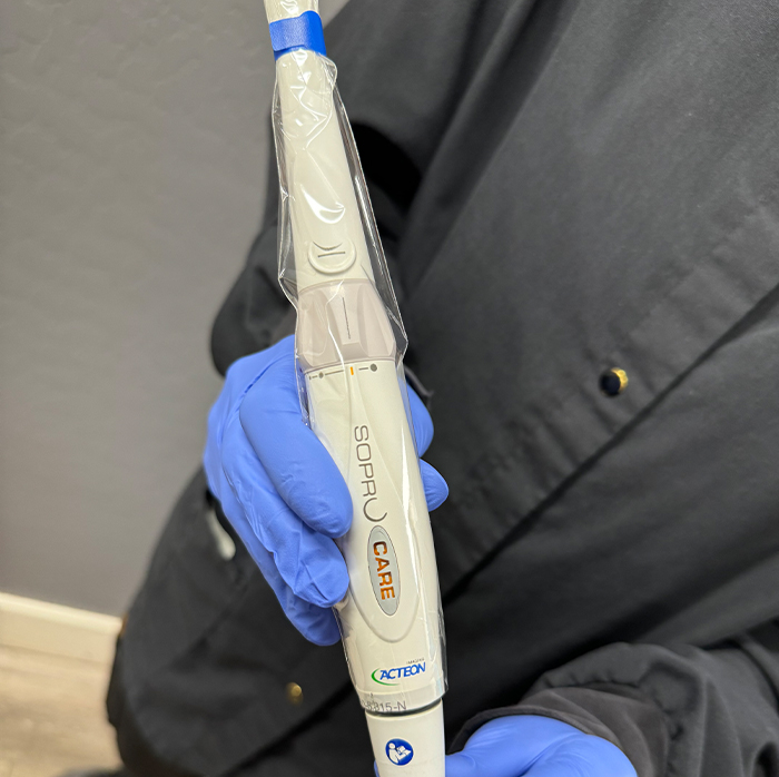 Dental team member holding white intraoral camera