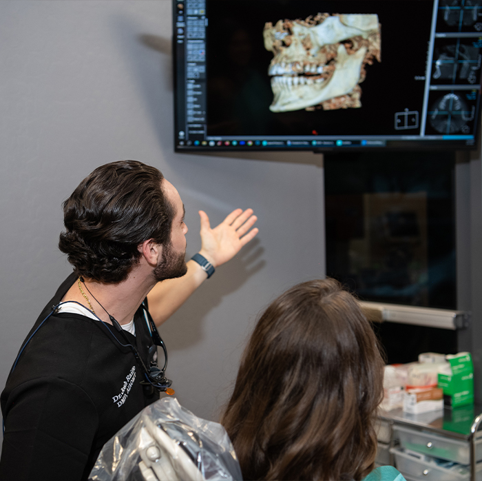 Doctor Raiffe showing a patient digital images of their jaws and teeth