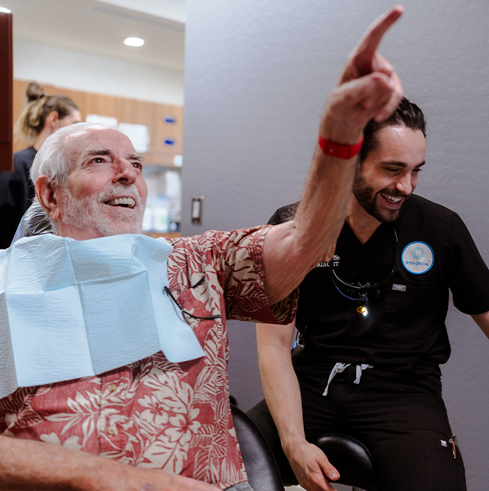 Man in dental chair pointing to something offscreen in Scottsdale dental office