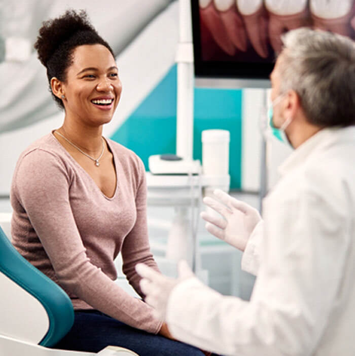 patient smiling while talking to dentist