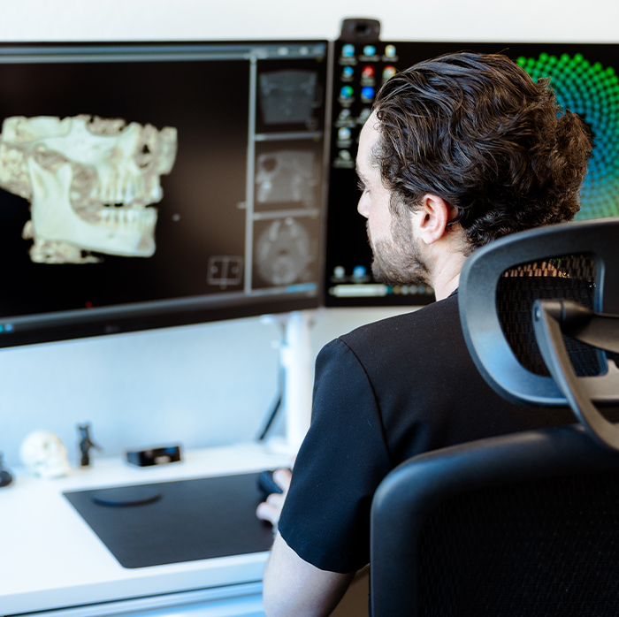 Doctor Raiffe looking at digital models of the jaw on computer monitor