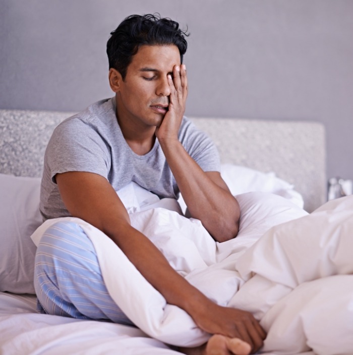 Man in bed waking up tired before sleep apnea treatment in Scottsdale