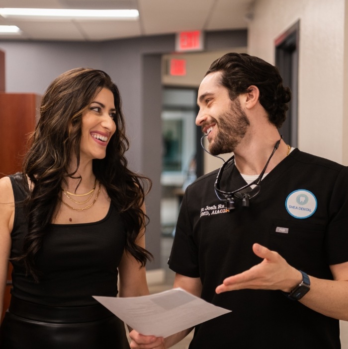 Dentist showing a patient a paper with dental special offers in Scottsdale